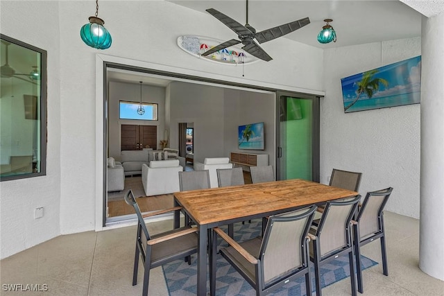 dining room featuring ceiling fan and a textured wall