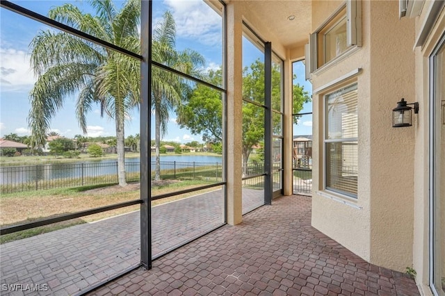 unfurnished sunroom featuring a water view and plenty of natural light