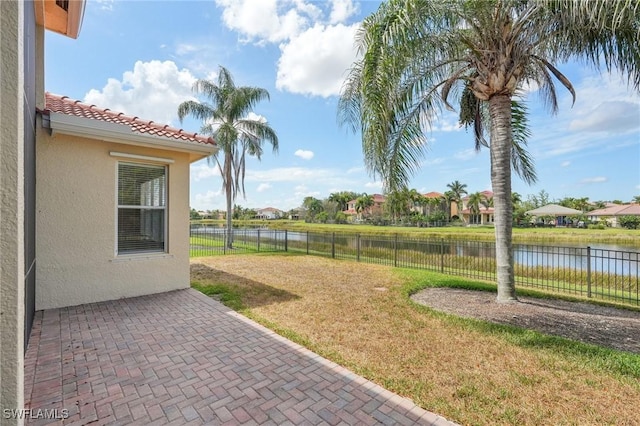 view of yard with a water view and a patio