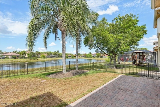 view of yard featuring a playground, a water view, and a patio