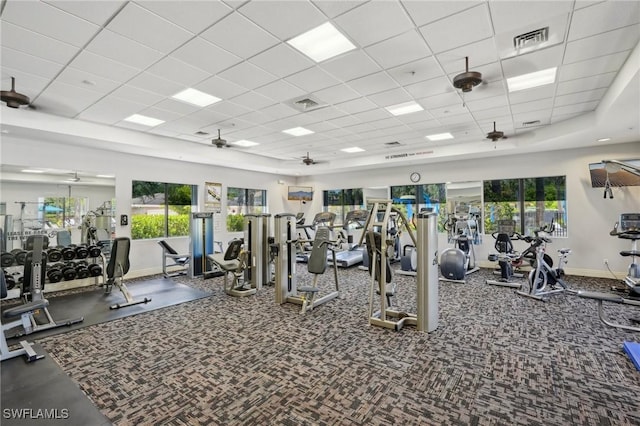 gym with a drop ceiling, baseboards, plenty of natural light, and ceiling fan