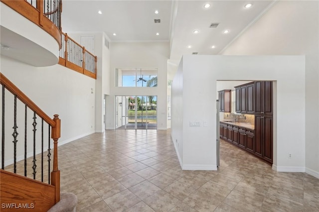 foyer entrance with a towering ceiling, baseboards, stairs, light tile patterned floors, and recessed lighting