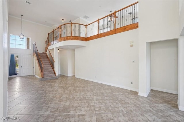 unfurnished living room with a high ceiling, stairs, baseboards, and arched walkways