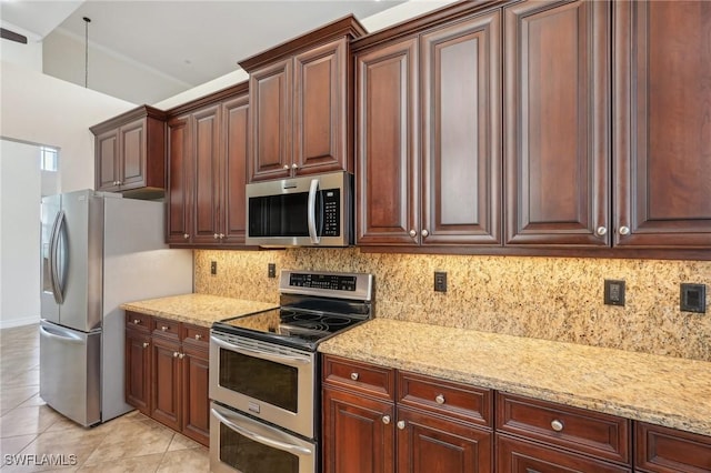 kitchen featuring stainless steel appliances, light tile patterned flooring, light stone counters, and backsplash