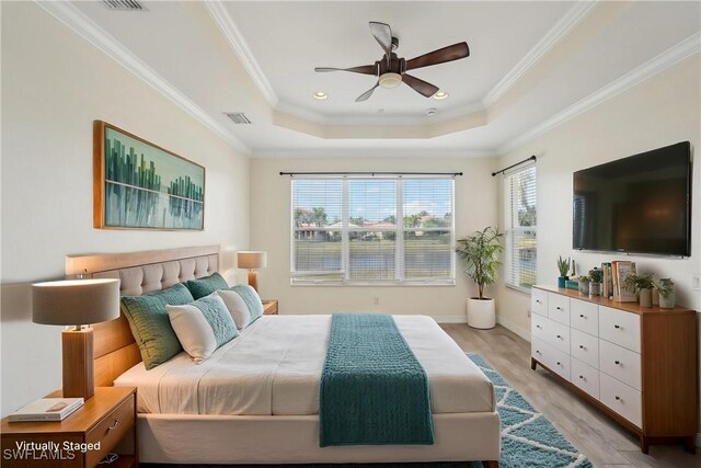 bedroom featuring a raised ceiling, light wood-style flooring, crown molding, ceiling fan, and recessed lighting