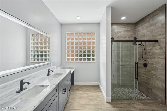 full bathroom with a shower stall, wood finished floors, plenty of natural light, and baseboards