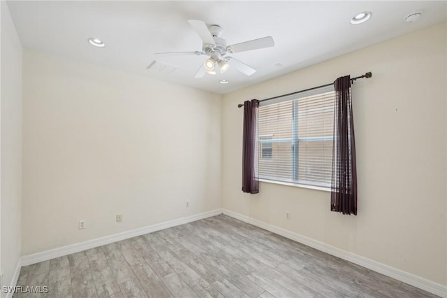 empty room with wood finished floors, a ceiling fan, baseboards, recessed lighting, and a smoke detector