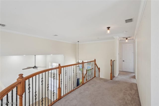 hallway with an upstairs landing, carpet floors, and crown molding