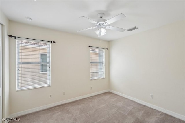 empty room with light colored carpet, baseboards, and ceiling fan