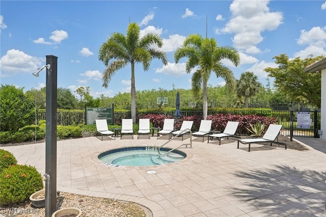 view of swimming pool with a hot tub, fence, and a patio area
