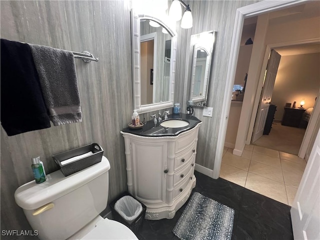 bathroom with tile patterned flooring, vanity, baseboards, and toilet