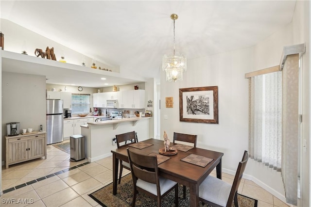 dining space featuring light tile patterned floors and a chandelier