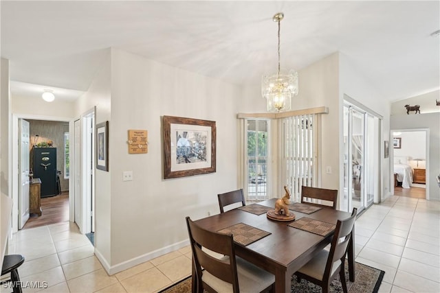 dining area with light tile patterned flooring, a chandelier, and baseboards