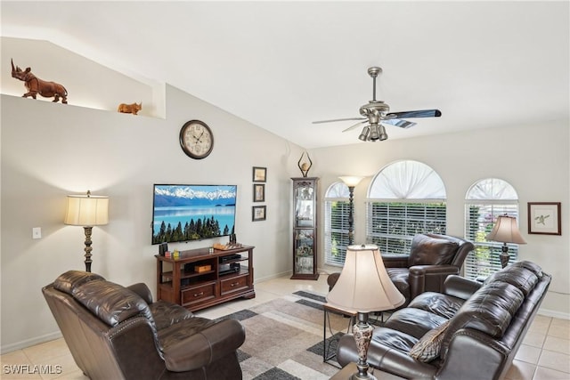 living area with ceiling fan, lofted ceiling, light tile patterned floors, and baseboards