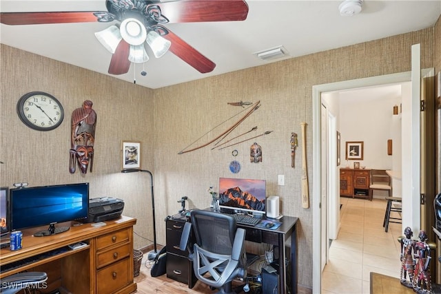 office space featuring wallpapered walls, a ceiling fan, and light tile patterned floors
