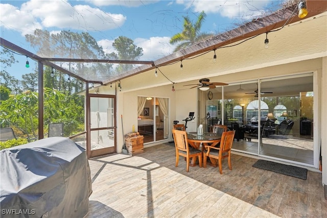 sunroom featuring a ceiling fan and outdoor dining area