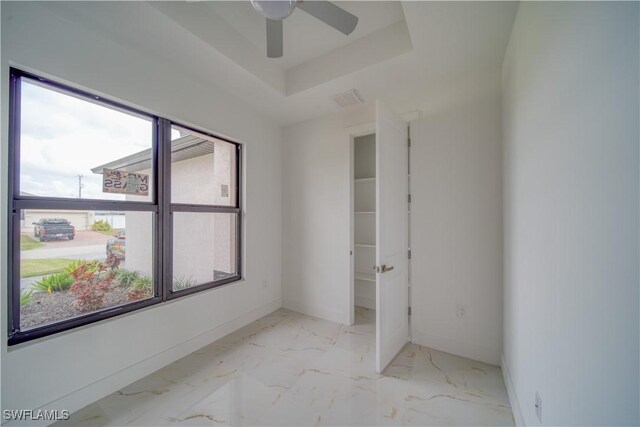 710 SW 25th Ln, Cape Coral, FL 33914 - spare room with baseboards, ceiling fan, marble look tiles, and a raised ceiling