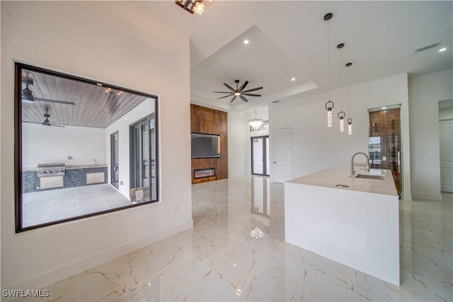 710 SW 25th Ln, Cape Coral, FL 33914 - kitchen featuring a sink, light marble finish floors, a fireplace, baseboards, and a ceiling fan