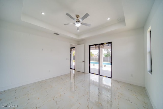 710 SW 25th Ln, Cape Coral, FL 33914 - empty room with a raised ceiling, light marble finish floors, ceiling fan, baseboards, and recessed lighting