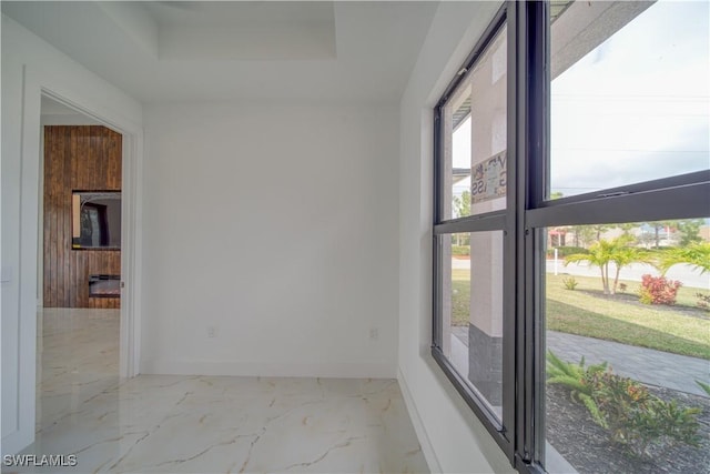 710 SW 25th Ln, Cape Coral, FL 33914 - empty room featuring a tray ceiling, baseboards, and marble finish floors