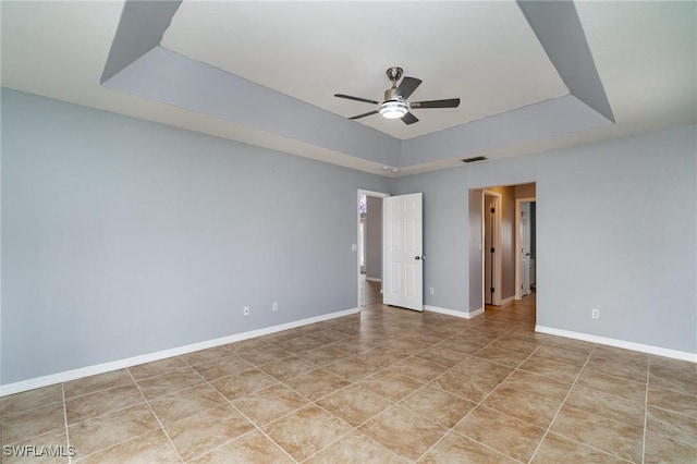 3113 SW 22nd Pl, Cape Coral, FL 33914 - empty room with a raised ceiling, a ceiling fan, light tile patterned floors, and baseboards