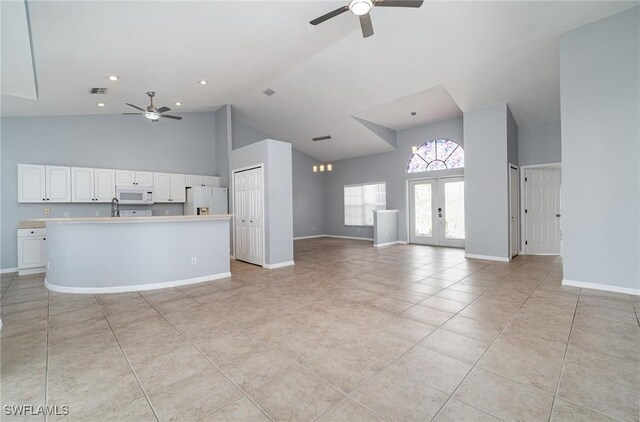 3113 SW 22nd Pl, Cape Coral, FL 33914 - unfurnished living room with a ceiling fan, high vaulted ceiling, light tile patterned floors, baseboards, and a sink