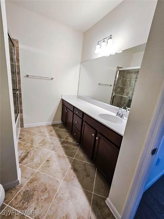 2685 Citrus St, Naples, FL 34120 - bathroom featuring toilet, a tile shower, tile patterned floors, baseboards, and vanity