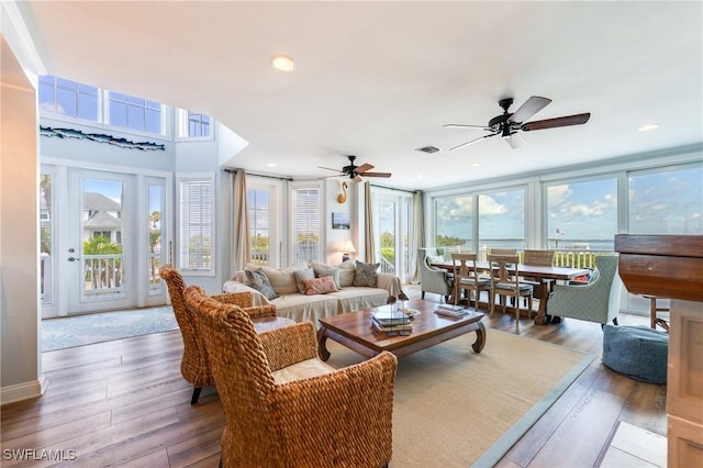 living room with healthy amount of natural light, ceiling fan, wood finished floors, and recessed lighting