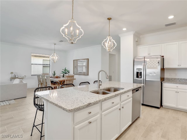 kitchen with a sink, stainless steel appliances, a chandelier, a kitchen island with sink, and hanging light fixtures