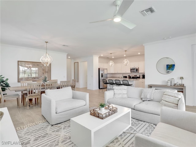 living area with ornamental molding, a ceiling fan, recessed lighting, and a chandelier