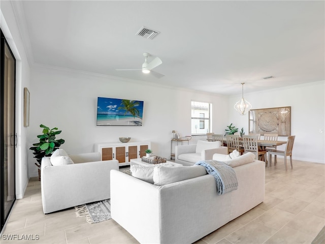 living area featuring ornamental molding, ceiling fan, and a chandelier