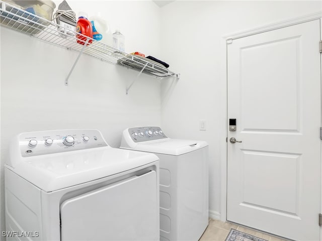washroom featuring washing machine and dryer and light tile patterned floors