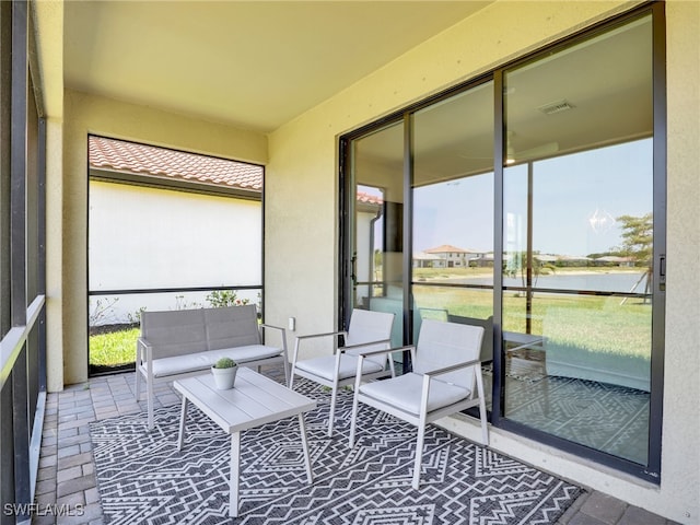 sunroom / solarium featuring a water view