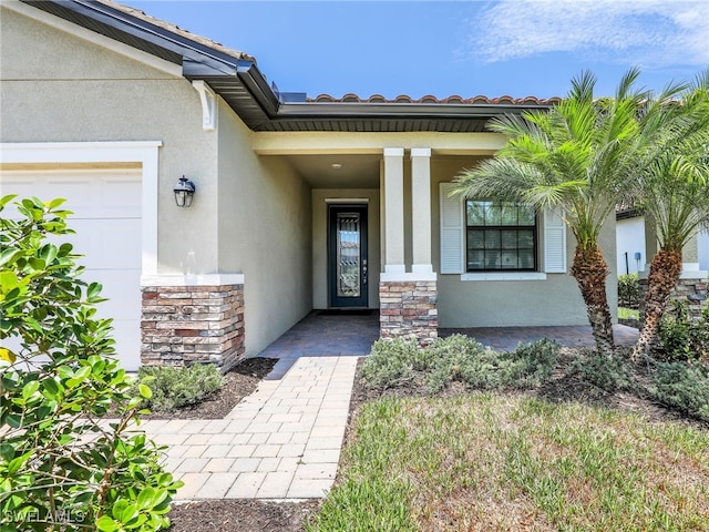 view of exterior entry featuring stucco siding, stone siding, and a porch