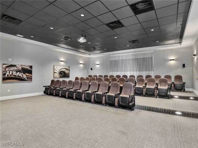 cinema room featuring carpet floors, baseboards, a drop ceiling, and a tray ceiling