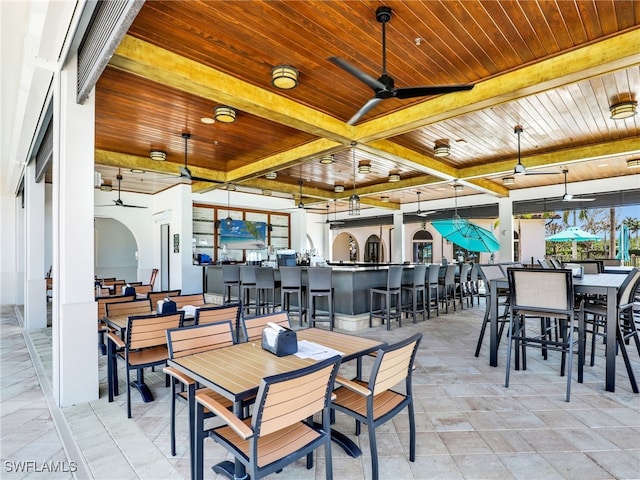 view of patio with ceiling fan, an outdoor bar, and outdoor dining area
