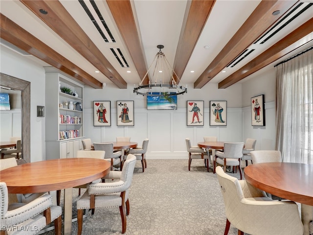dining area featuring a chandelier, carpet flooring, beamed ceiling, a decorative wall, and recessed lighting