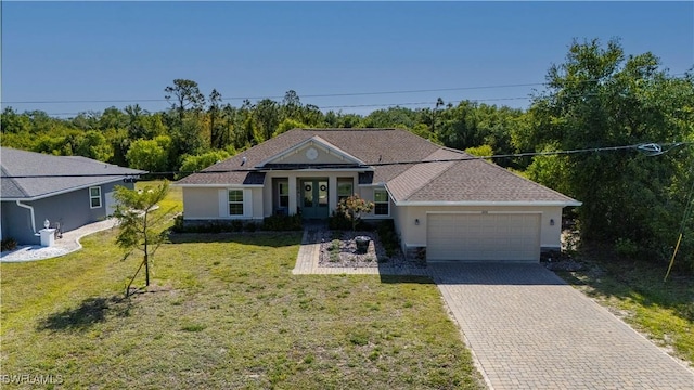 view of front of property featuring an attached garage, french doors, driveway, stucco siding, and a front lawn