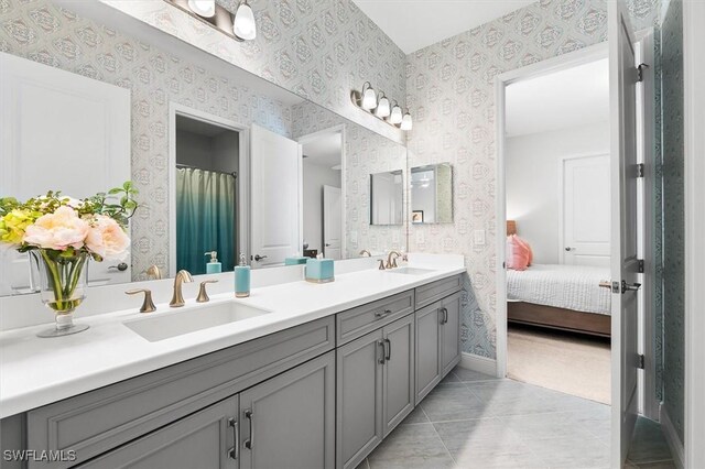 full bath with wallpapered walls, double vanity, ensuite bathroom, baseboards, and tile patterned floors