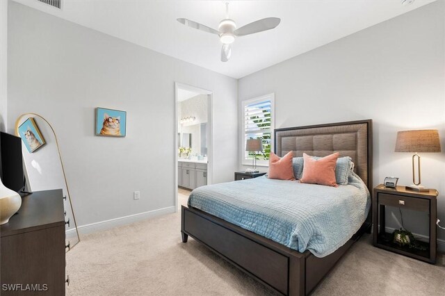 carpeted bedroom with baseboards, connected bathroom, and a ceiling fan