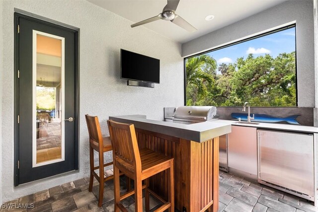 view of patio with a grill, an outdoor kitchen, and a ceiling fan