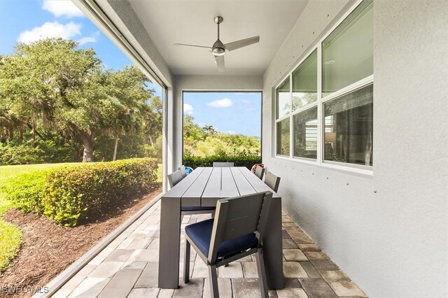 sunroom featuring stone finish floors, healthy amount of natural light, and a textured wall