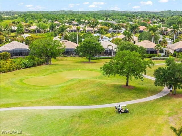 view of property's community with view of golf course, a residential view, and an area to practice putting