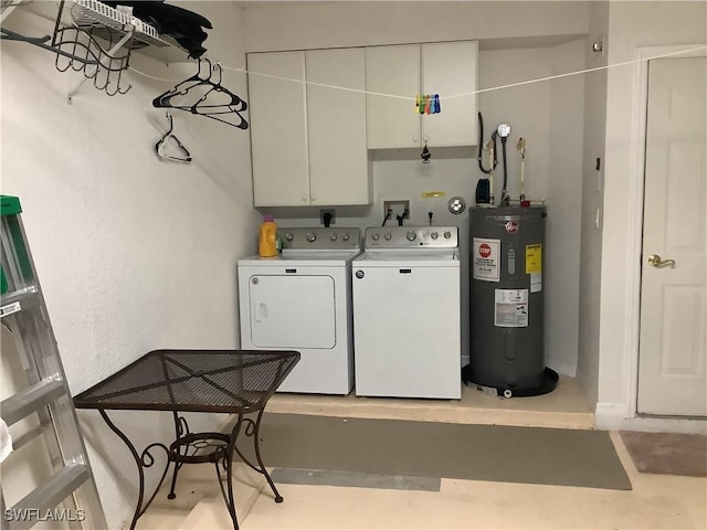 laundry area featuring electric water heater, independent washer and dryer, and cabinet space