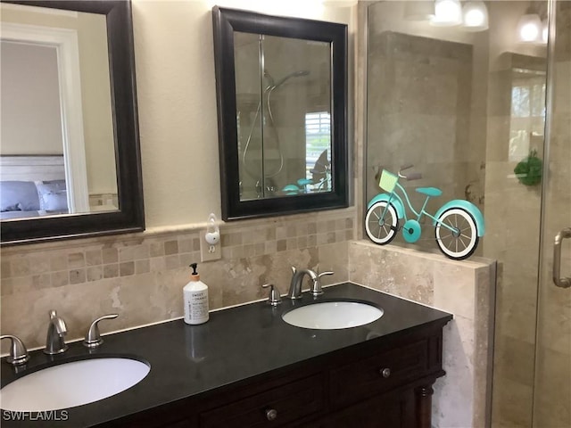full bath with double vanity, tasteful backsplash, a stall shower, and a sink