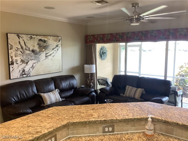 living area with ceiling fan, ornamental molding, and visible vents