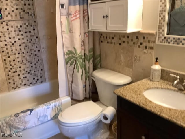 bathroom featuring toilet, shower / tub combo with curtain, and vanity