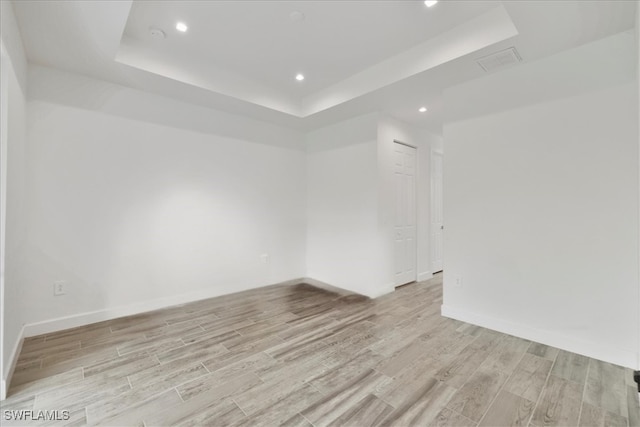 409 Columbus Blvd S, Lehigh Acres, FL 33974 - empty room featuring a raised ceiling, light wood-type flooring, recessed lighting, and baseboards
