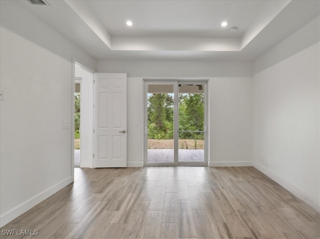 409 Columbus Blvd S, Lehigh Acres, FL 33974 - empty room featuring a raised ceiling, light wood-type flooring, baseboards, and recessed lighting