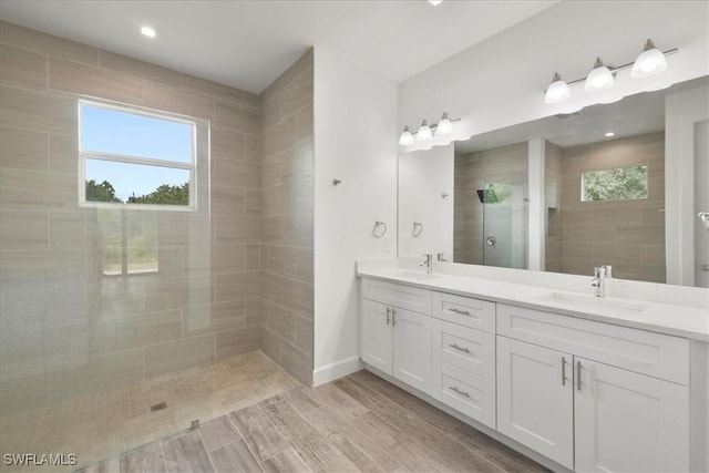 409 Columbus Blvd S, Lehigh Acres, FL 33974 - full bath with a tile shower, double vanity, plenty of natural light, and wood tiled floors